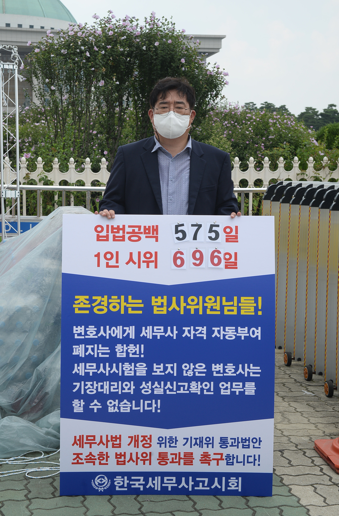 이창식 회장이 세무사법 개정안의 법사위 통과를 촉구하는 내용의 피켓을 들고 1인 시위를 벌이고 있다.