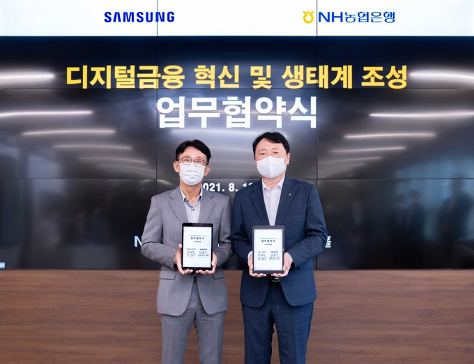 권준학 은행장(오른쪽)과 강봉구 삼성전자 한국총괄 부사장이 업무협약 기념촬영을 하고 있다.(사진=농협은행)