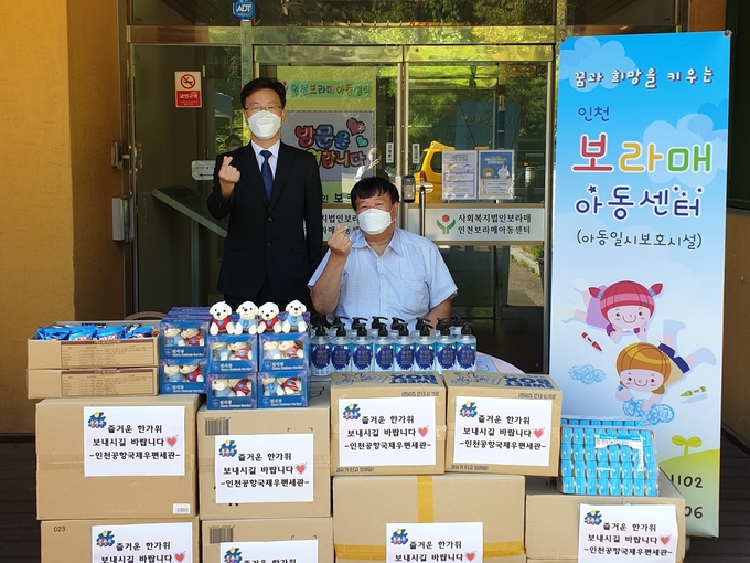 김기동(왼쪽) 인천공항우편세관장이 인천보라매아동센터를 찾아 이계윤 원장에게 위문품을 전달하고 있다.