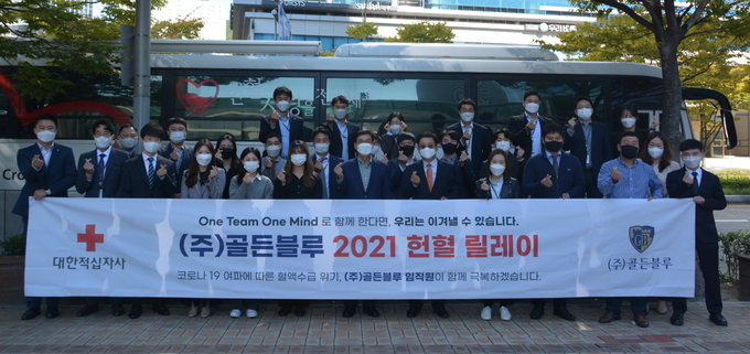 부산 센텀 사이언스파크 빌딩 앞에 배치된 헌혈차량 앞에서 골든블루 박용수 회장(앞줄 왼쪽 일곱번째)을 비롯한 임직원들이 단체 사진을 촬영하고 있다.