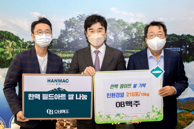 (왼쪽부터) 윤현탁 오비맥주 마케팅 부장, 유희문 오비맥주 마케팅 부사장, 이상천 제천시장이 기탁식에서 기념사진을 찍고 있다.