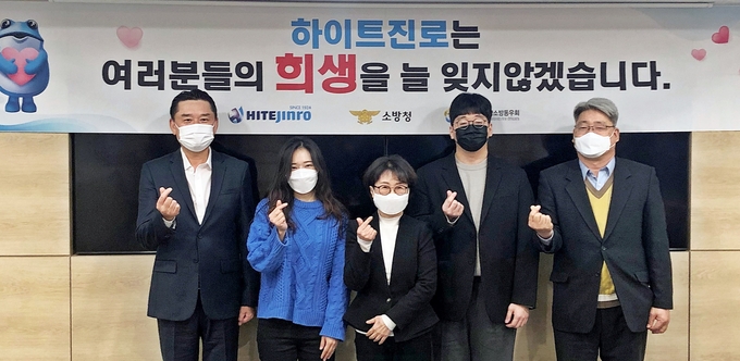 소방 유자녀 장학금 기증식에 하이트진로 김인규 대표(왼쪽 첫번째)와 소방청 이종재 복지계장(오른쪽 첫번째), 유가족이 참석해 기념촬영하고 있다. 