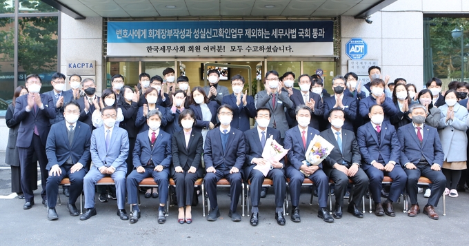 한국세무사회 사무국 직원들과 임원진이 세무사법 개정안의 국회 통과를 기뻐하며 기념촬영하고 있다. 