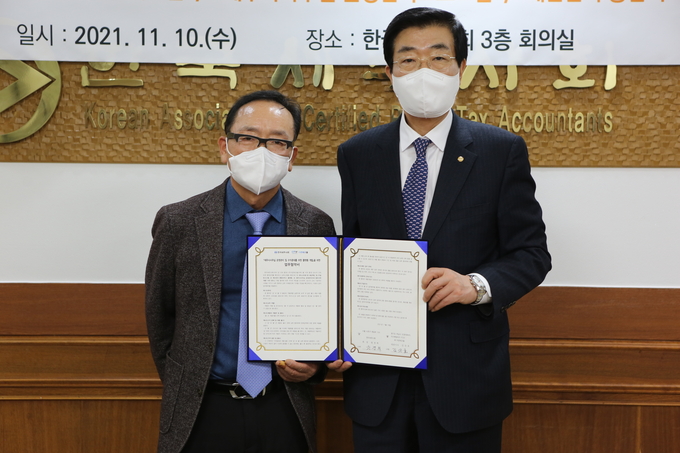 원경희<오른쪽> 한국세무사회장과 김진호 더존테크윌 대표이사가 업무협약을 체결하고 있다. 