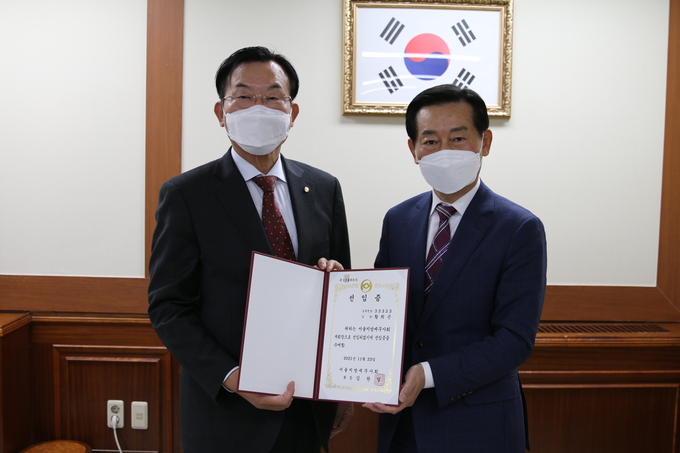 김완일 서울회장이 황희곤 부회장<오른쪽>에게 선임증을 전달하고 있다. 