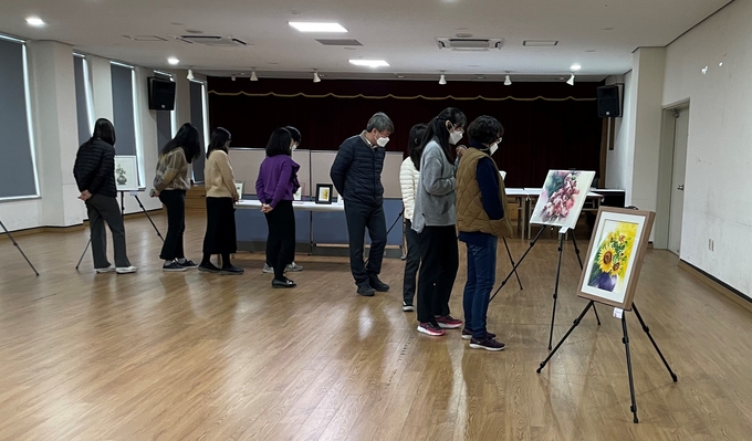 안양세무서 직원들이 청사 1층 대회의실에 전시된 '올 그리다' 동호회 작품을 관람하고 있다.