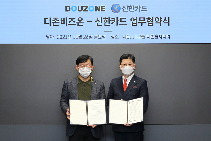 지용구 더존비즈온 솔루션사업부문대표(오른쪽)와 김선건 신한카드 원신한사업본부장이 협약서를 교환하고 있다.