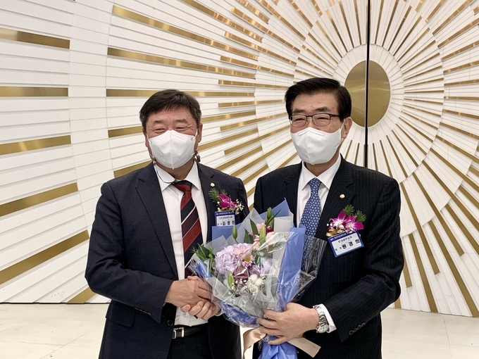 원경희 한국세무사회장<오른쪽>이 세무사법 개정 축하 꽃다발을 김명진 인천지방회장으로부터 받고 있다. 