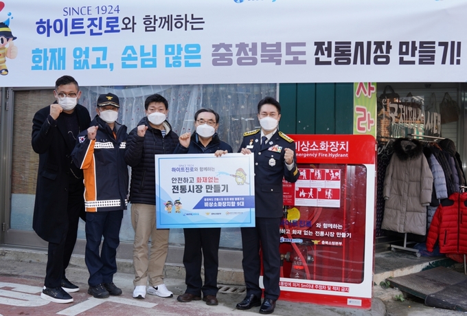 하이트진로는 소방청 관계자들과 함께 충북 청주 사창시장을 시작으로 8개 전통시장에 비상소화장치함을 설치한다. 지난 2일 청주 사창시장에서 채열식 청주서부소방서장(오른쪽 첫번째) 등 소방청 관계자들과 상인회 관계자들이 기념사진을 찍고 있다. 
