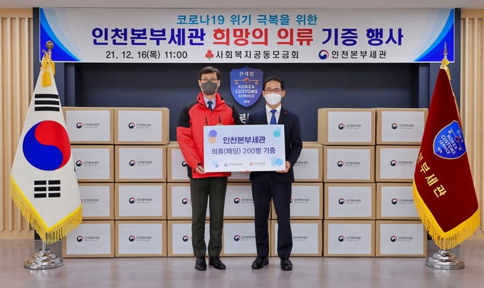 최능하 인천본부세관장(왼쪽)이 이정윤 인천 사회복지공동모금회 사무처장과 희망의 의류 기증식을 갖고 있다.