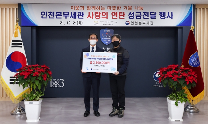 최능하 인천세관장(왼쪽)이 정성훈 인천연탄은행 대표에 사랑의 연탄 성금을 전달하고 있다.(사진=인천세관)