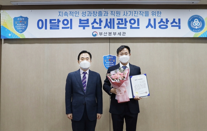 김재일 부산세관장(왼쪽)이 올해의 부산세관인으로 선정된 정종석 관세행정관과 기념사진을 찍고 있다.(사진=부산세관)