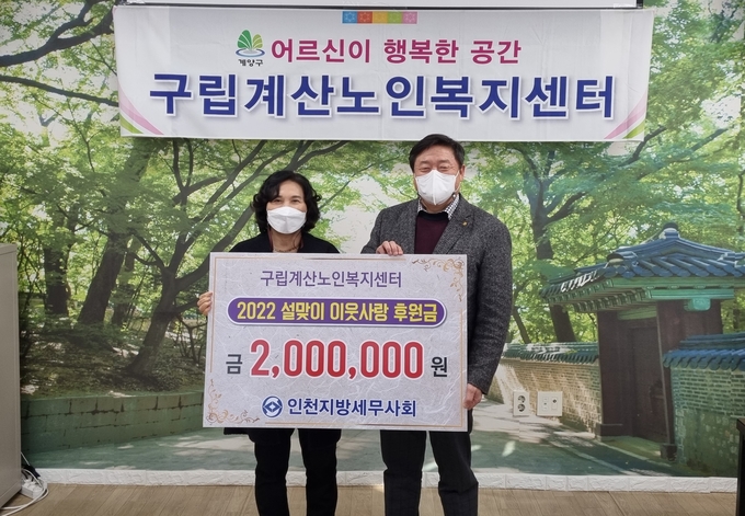 김명진 인천세무사회장(오른쪽)이 김명숙 구립계산노인복지센터장에 이웃돕기성금을 전달하고 있다.