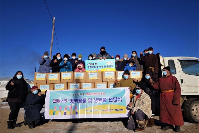 몽골 카스 희망의 숲 인근 하늘마을 주민들이 푸른아시아의 현지 활동가와 따숨박스 전달식에 참석해 기념사진을 찍고 있다.