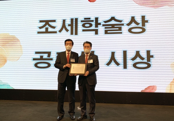 원경희 한국세무사회장이 정구정<오른쪽> 전 한국세무사회장에게 조세학술상 공로상을 시상하고 있다.