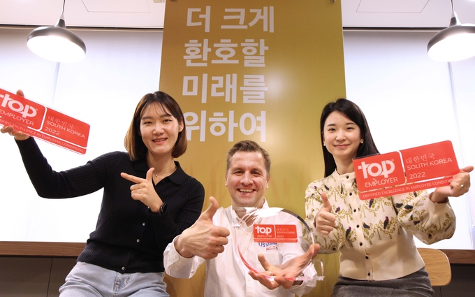 오비맥주 배하준 대표(가운데)가 '최고 고용주 협회'가 수여하는 '2022 최우수 고용기업' 상을 받고 직원들과 함께 기념촬영을 하고 있다.