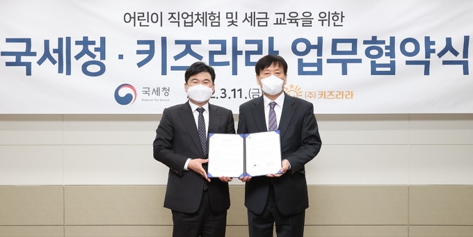 국세청은 11일 어린이 직업 체험시설 키즈라라와 ‘어린이 국세청 체험관 운영’에 대한 업무협약을 체결했다,<송바우(왼쪽) 국세청 징세법무국장과 최영근 키즈라라 대표가 기념 촬영하고 있다><사진=국세청>