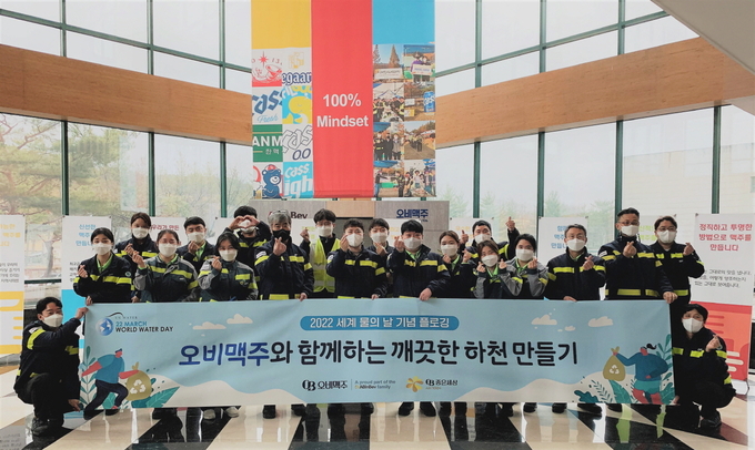 오비맥주 청주 생산공장 임직원들이 공장 인근 하천 정화 활동에 나서며 기념 사진을 찍고 있다.(사진제공 오비맥주)