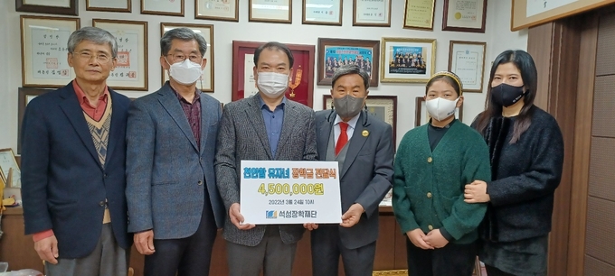 석성장학회 조용근 이사장<왼쪽 네번째>이 천안함 유족 대표에게 장학금을 전달하고 있다. 