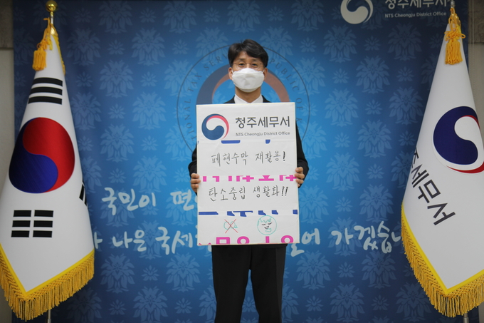 박광식 청주세무서장이 폐현수막으로 제작한 ‘폐현수막 재활용! 탄소중립 생활화!!’ 팻말을 들고 '탄소중립 챌린지'에 동참하고 있다.