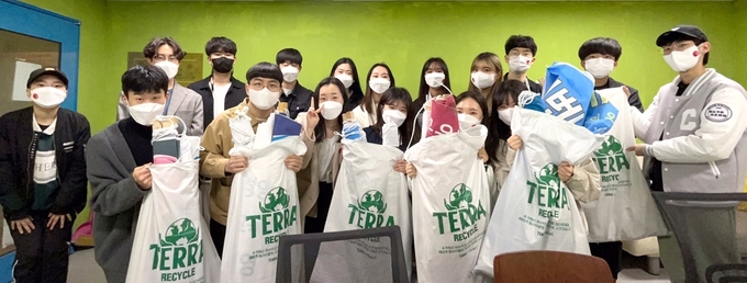 중앙대학교 환경동아리 '지구인' 회원들이 테라 맥아 포대를 활용해 대학가에서 수거한 현수막들을 들고 있다.