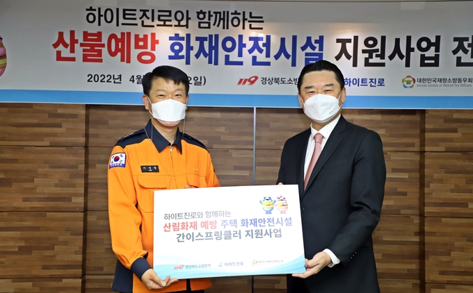 김인규 하이트진로 대표(오른쪽)과 이영팔 경북소방본부장이 지난 8일 경북소방본부에서 산림 화재 예방 화재안전시설 지원을 위한 전달식을 갖고 있다.(사진=하이트진로)