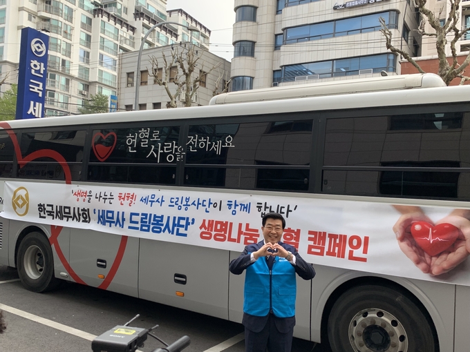 원경희 한국세무사회장이 헌혈차 앞에서 기념촬영하고 있다. 