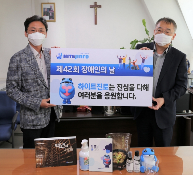 하이트진로는 지난 19일 서울 강남구 하상장애인복지관에서 장애이웃에 위생용품과 식료품을 전달했다.<하이트진로 정세영 수석팀장(왼쪽)이 하상장애인복지관 허명환 관장과 기념촬영하고 있다. 사진=하이트진로>