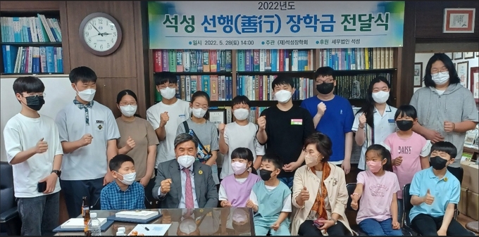 조용근<앞줄 왼쪽 두번째> 석성장학회 이사장이 선행 학생들을 격려하며 이들과 화이팅하고 있다. 