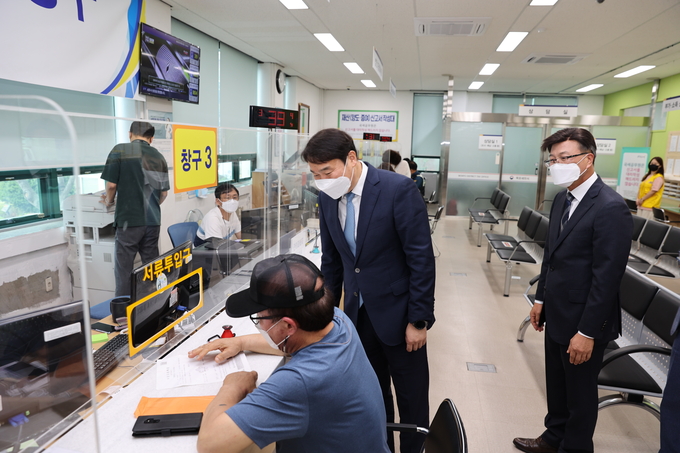 윤영석 광주청장<오른쪽 두 번째>이 노현탁 목포서장의 안내로 한 민원인의 부가세 신고를 살피고 있다. 