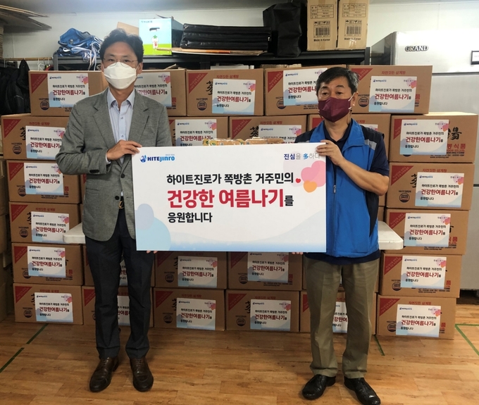 정세영 하이트진로 수석팀장(왼쪽)과 박종태 서울특별시립남대문쪽방상담소장이 11일 서울시 남대문 쪽방상담소에서 쪽방촌 거주민의 '건강한 여름나기' 지원식을 갖고 있다.(사진=하이트진로)