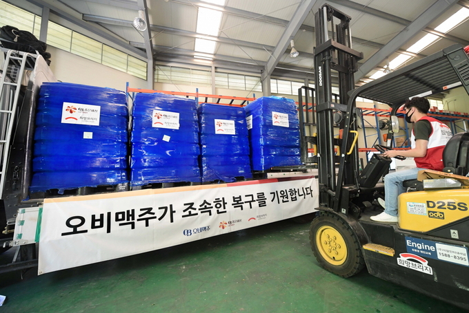 오비맥주가 기부한 생수를 희망브리지 파주 물류센터에서 차량에 싣고 있다.(사진=오비맥주)