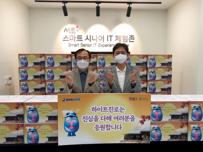 정세영 하이트진로 수석팀장(오른쪽)과 이성희 서초구립 중앙노인종합복지관장이 명절 음식 전달식을 갖고 있다.(사진=하이트진로)