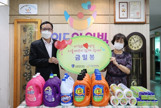정승환(왼쪽) 서울본부세관장이 사회복지시설 이든아이빌을 찾아 생활용품과 성금을 전달하고 있다.