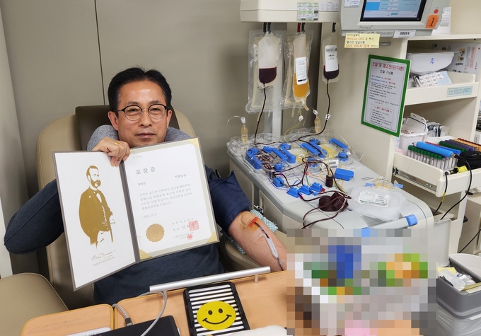 중부지방국세청 박종일 반장이 대한적십자사로부터 헌혈유공 포장장을 받고 있다.