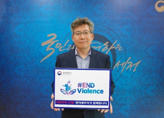 정규호 영덕서장이 "아동폭력 근절! 영덕세무서가 함께 합니다'라는 팻말을 들고 ‘END Violence 캠페인’에 동참하고 있다. 