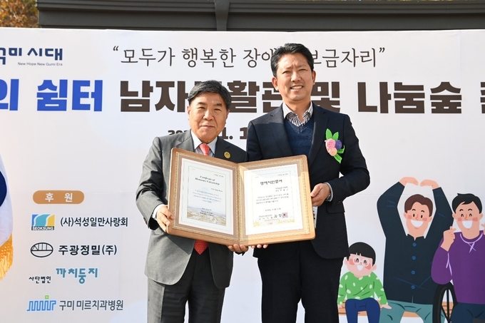 조용근(왼쪽) 석성1만사랑회장이 구미시 명예시민증을 받고 있다.