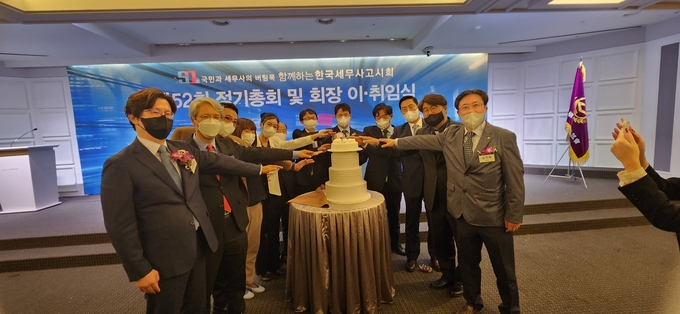 정기총회에 참석한 내외빈이 케이크를 절단하고 있다.