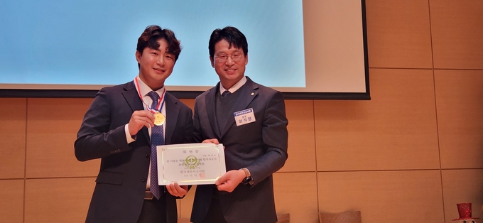  이석정(오른쪽) 회장이 강현호 세무사에게 기념메달을 수여했다.