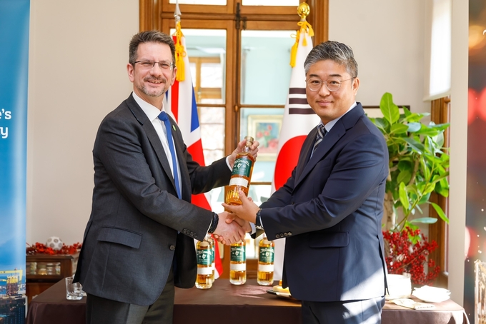 ㈜골든블루는 지난달 8일 주한영국대사관 대사관저에서 J&J 맥코넬스 LTD와 ‘맥코넬스’의 독점 수입⋅유통계약을 체결했다.<(왼쪽부터) 스티브 베이커 북아일랜드 부장관, ㈜골든블루 인터내셔널 김관태 마케팅본부장>