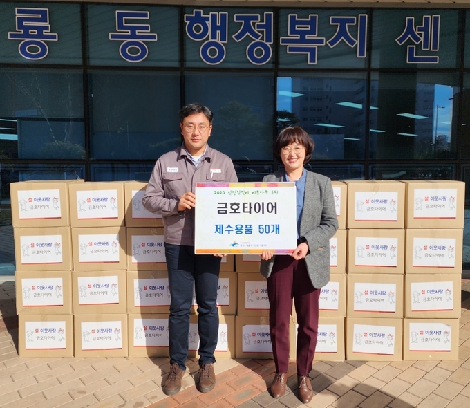 김재호(왼쪽) 금호타이어 관리팀장이 이정은 광산구 어룡동 행정복지센터 동장에게 제수용품을 전달하고 있다. 