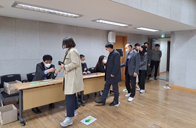제1투표소가 설치된 본회를 방문한 회원들이 기표에 앞서 신분증을 제시하고 있다.