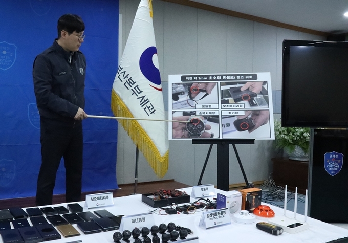 부산세관 조사1관실 담당 수사반장이 손목시계 등으로 위장한 초소형카메라의 주요 촬영부위를 설명하고 있다.