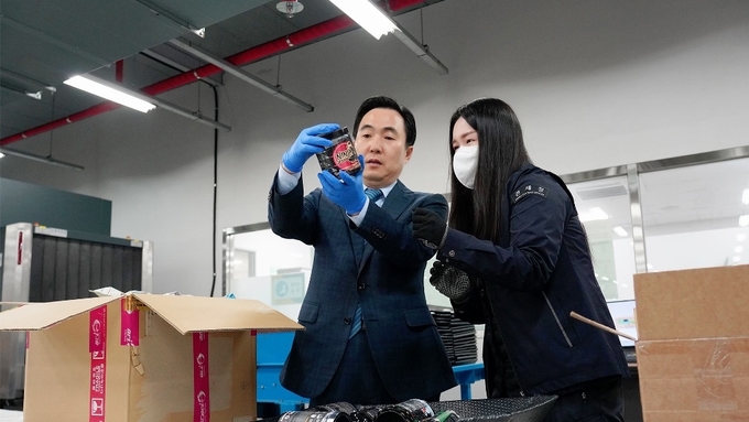 김재일(왼쪽) 인천공항본부세관장이 지난 18일 특송우편통관국을 찾아 검사대상으로 지정된 해외직구 물품을 살피고 있다.