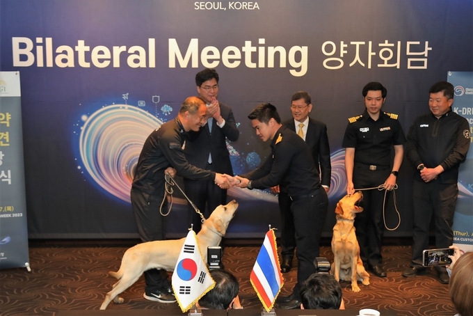 관세청 직원이 태국 세관 직원에게 마약탐지견을 기증하고 있다.