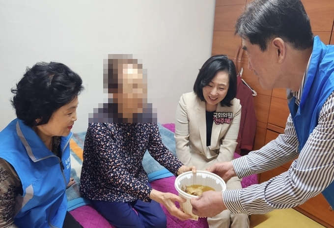 황선의 국세동우회 자원봉사단장, 전주혜 의원, 이상위 부단장이 노인 분에게 닭백숙을 전달하고 있다<오른쪽부터>. 