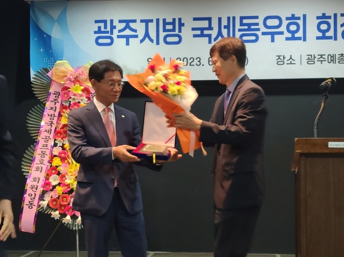 김기호 광주지방국세동우회 신임회장<오른쪽>이 김성후 회장에게 감사패와 꽃다발을 전달했다.
