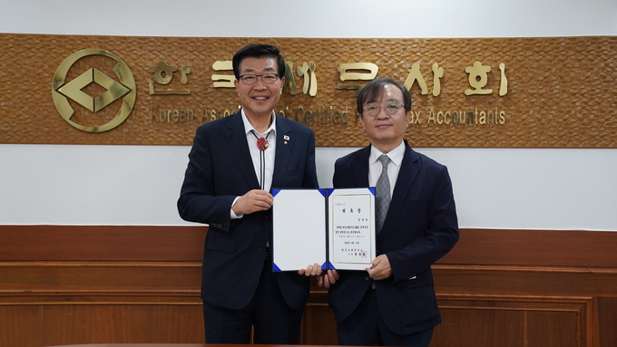 원경희 한국세무사회 부설 조세연구소장이 김갑순 교수에게 위촉장을 전달하고 있다. 