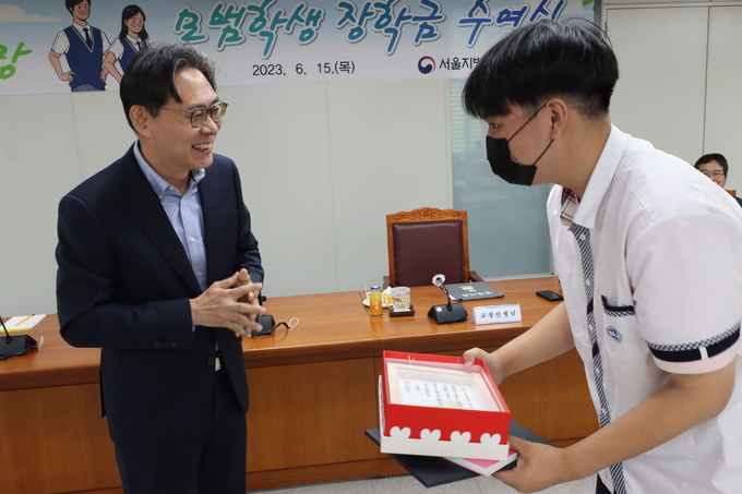 강민수 서울청장(왼쪽)이 대동세무고 학생에게 장학금을 전달하고 있다. 