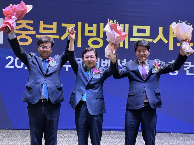 이중건<가운데> 23대 중부지방세무사회장과 이재실<왼쪽>·김대건 부회장이 당선 선포 후 회원들에게 인사하고 있다. 